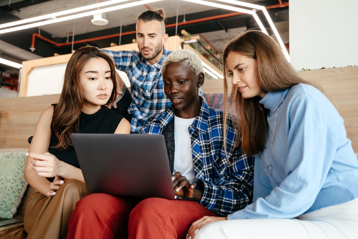 Diverse team collaborating around a laptop
