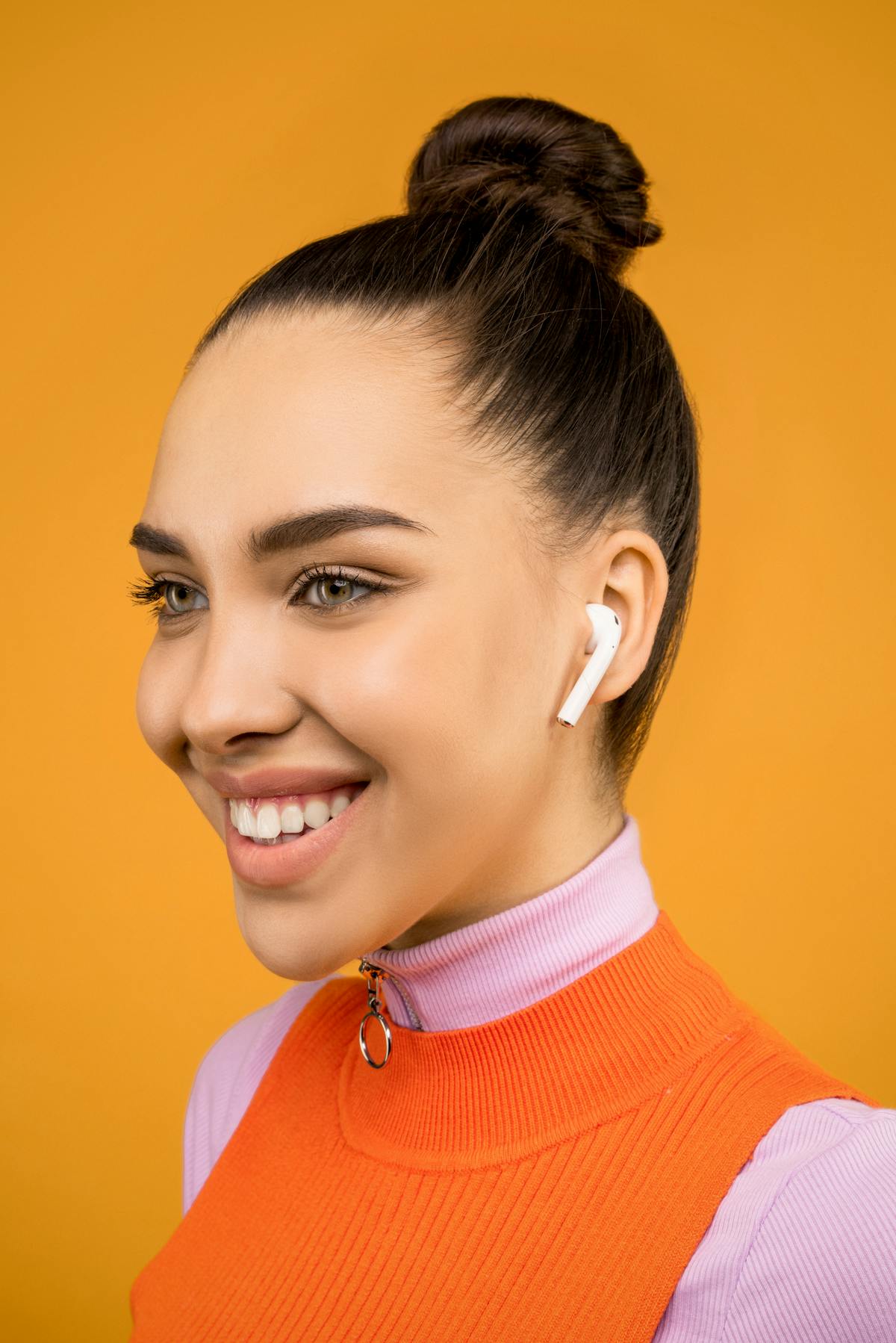 Young woman with AirPods smiling energetically